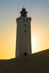 Wall Mural - Lighthouse at Rubjerg Knude, Denmark against setting sun