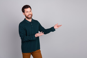 Wall Mural - Photo of attractive nice bearded man wear stylish clothes presenting empty space isolated on gray color background