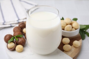 Sticker - Glass of macadamia milk and nuts on white tiled table, closeup