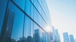 © Theeranan - Corporate building exterior with tall glass windows reflecting the city skyline in bright daylight.