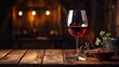 © somporn - A wine glass filled with red wine on a rustic wooden table
