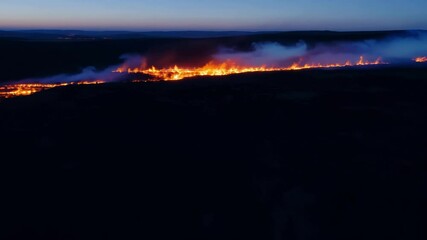 Poster - Intense wildfire rages through dense forest at night, illuminating landscape with fiery glow, creating mesmerizing display of destruction and danger