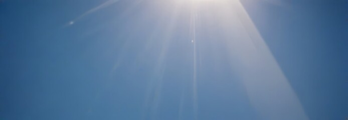 Fototapete - Sunlight streams down from the top right corner, casting a warm glow on the clear blue sky