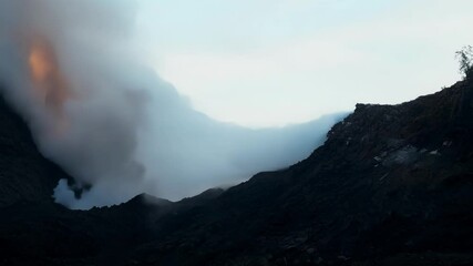 Poster - Molten lava is spewing from the crater of a volcano, creating a thick plume of smoke and ash that rises into the twilight sky