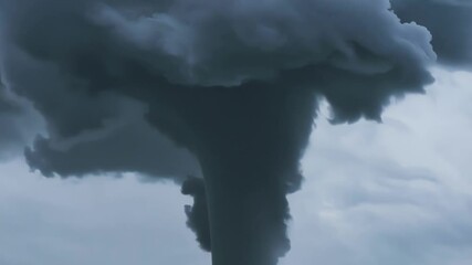 Wall Mural - Large and powerful tornado is forming from dark storm clouds, bringing with it the threat of destruction and devastation