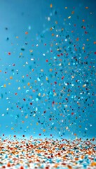 Aufkleber - A vibrant array of multicolored confetti, in shades of red, orange, yellow, green, blue, and white, is captured in mid-air, creating a dynamic and festive atmosphere against