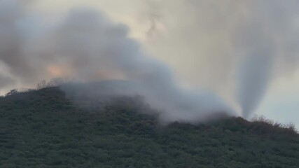 Poster - Helicopter battles a wildfire, sending smoke into the air and threatening nature below. The blaze highlights dangers of fires and the need for emergency response to protect the environment