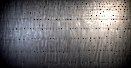 Fototapete - a close-up view textured surface with a pattern of small holes or perforations, creating a sense of depth and dimension