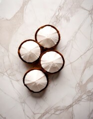Fototapete - Four halved coconut shells arranged in a diagonal line on a marble surface