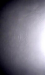 Poster - a blurred, dark gray background with a faint, wispy pattern of white lines or shapes in the center, creating a sense of depth and movement