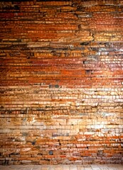 Fototapete - a close-up view brick wall, with the bricks arranged in a staggered pattern and displaying a range of colors from red to brown