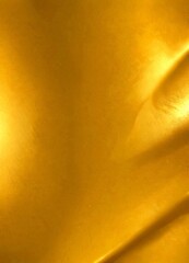 Poster - a close-up view shiny, golden surface with a subtle texture, creating a warm and inviting atmosphere