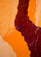 Aufkleber - a close-up view marble surface with a striking contrast between the orange and maroon colors The orange marble is slightly lighter in color than the maroon, creating a