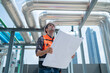 © Washburn - Engineer Inspecting Industrial Pipes on Rooftop
