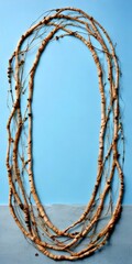 Aufkleber - A circular arrangement of light brown tree branches with small leaves, set against a light blue background
