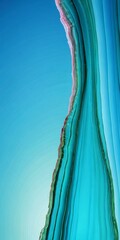 Aufkleber - a close-up view of a vibrant, multicolored rock formation, with a gradient of blue, green, and pink hues. The rock appears to be made of layers of different colored