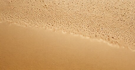 Poster - a close-up view of a sandy beach, with the sand's surface appearing wet and textured, and small holes or holes scattered across the sand.