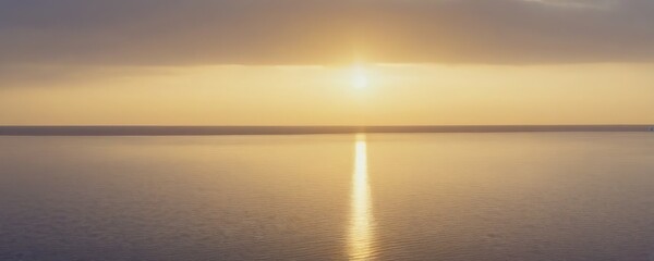 Poster - A serene sunset over a calm body of water, with the sun's reflection creating a long, straight line across the surface