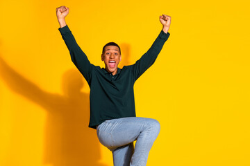 Canvas Print - Photo of nice young man raise fists wear pullover isolated on bright yellow color background