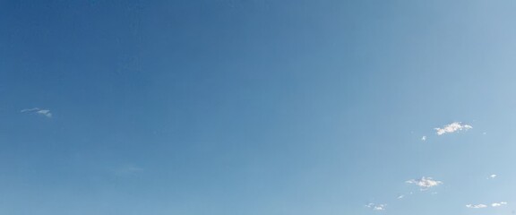Poster - A clear blue sky with a few scattered clouds