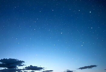 Aufkleber - A starry night sky with a few clouds and a faint outline sunrise or sunset