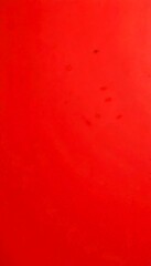 Fototapete - a close-up view of a red surface with small black spots scattered across it.