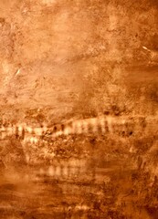 Fototapete - a textured surface with a warm, earthy tone, resembling a stone or brick wall. The surface has a rough, uneven texture, and the colors are predominantly brown and orange,