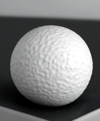 Poster - A close-up white sphere with a textured surface, resting on a dark surface
