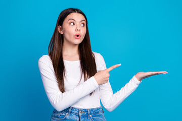 Poster - Photo portrait of pretty teen girl point hold look empty space wear trendy white outfit isolated on blue color background