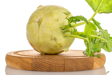 One ripe kohlrabi on a wooden tray, macro, isolated on white background.