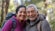 © NickArt - A senior Hispanic couple smiling warmly while enjoying a day outdoors in nature.