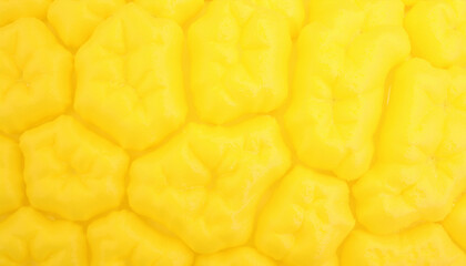 Close-up bright yellow textured surface resembling foam or sponge for abstract background