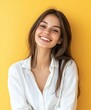 © BrandwayArt - Young woman smiling with long hair against a bright yellow background