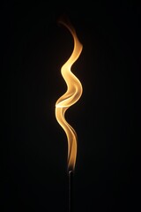 Wall Mural - A long, thin flame is lit up in the dark. Concept of warmth and comfort, as well as a feeling of danger or risk. The flame is the only source of light in the image
