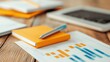 © Pinklife - An orange notebook rests on a wooden desk alongside colorful charts and a silver pen, suggesting a scene of business analysis or financial planning.