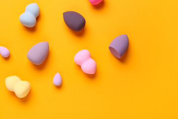 Sticker - Different makeup sponges on orange background