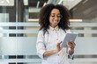 © Tetiana - Smiling doctor in white coat using tablet in modern office environment for professional communication