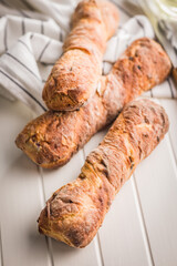 Canvas Print - Crusty rustic baguette on white table.