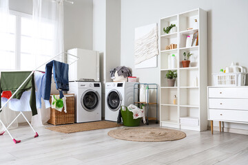 Interior of bathroom with washing machines, laundry basket and dryer