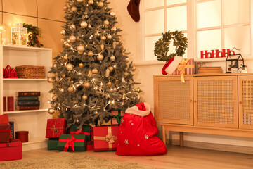 Sticker - Interior of cozy living room with Santa bag, gift boxes and Christmas tree decorated for holiday at night