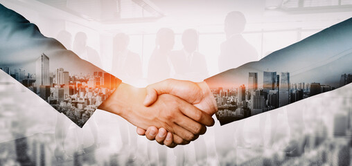 Double exposure image of business people handshake on city office building in background show partnership success of business deal. Concept of corporate teamwork, trust partner and work agreement. uds