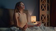 © stockbusters - Girl meditating late evening preparing to sleep in bedroom. Woman closing eyes