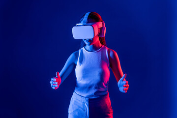 Smart Female standing surrounded by neon light wear VR headset connecting metaverse, futuristic cyberspace community technology, using both hands interact with generated virtual object. Hallucination.