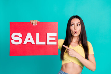 Sticker - Portrait of nice young woman point finger sale poster wear top isolated on turquoise color background