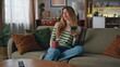 © stockbusters - Girl relaxing coffee cup holding smartphone. Woman enjoy beverage sitting home