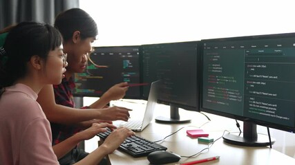 Slow motion back end software developer engineer for computer programming working together on debugging writing computing code, solving complex algorithms display on monitor in office. Burgeoning