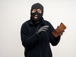 © Chanakon - Thief in uniform black jacket various pose on isolated background. The Robber terrorism criminal escapes with balaclava and crowbar entering a house for stealing Housebreak