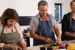 © Wavebreak Media - Slicing vegetables, senior diverse friends enjoying cooking class together in kitchen, at home