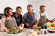 © Wavebreak Media - Cooking together, senior diverse friends preparing meal and chopping vegetables in kitchen, at home