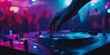 © kwanchaift - a DJs hand on the turntable in a packed nightclub, with colorful lights and dancing figures